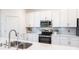Kitchen with white cabinets, stainless steel appliances, and a double sink at 14138 Poppy Field Loop # 4122, Punta Gorda, FL 33955