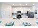 White kitchen with island, stainless steel appliances, and quartz countertops at 14138 Poppy Field Loop # 4122, Punta Gorda, FL 33955