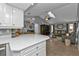 Open kitchen with white cabinets and view into living room with vaulted ceiling at 1435 Sea Fan Dr, Punta Gorda, FL 33950