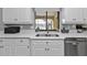 Modern kitchen features white cabinets, double sink, and stainless steel dishwasher at 1435 Sea Fan Dr, Punta Gorda, FL 33950
