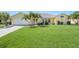 Well-maintained house with a lush green lawn and palm trees at 1717 Nuremberg Blvd, Punta Gorda, FL 33983