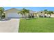 Bright yellow single-story home with palm trees and a two-car garage at 1717 Nuremberg Blvd, Punta Gorda, FL 33983