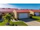 Tan house with red tile roof, white garage door, and landscaped yard at 1780 Deborah Dr # 15, Punta Gorda, FL 33950