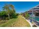 Landscaped backyard with tropical plants leading to the pool area at 18147 Cadillac Ave, Port Charlotte, FL 33948