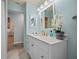 Bathroom with white vanity, light blue walls, and a large mirror at 18147 Cadillac Ave, Port Charlotte, FL 33948