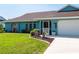 Front view of a charming teal home with well-maintained landscaping at 18147 Cadillac Ave, Port Charlotte, FL 33948