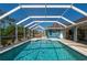 Relaxing screened pool area with patio furniture and home view at 18147 Cadillac Ave, Port Charlotte, FL 33948