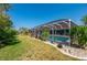Inviting pool with screened enclosure surrounded by a well-manicured lawn at 18147 Cadillac Ave, Port Charlotte, FL 33948