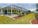 Landscaped backyard with screened enclosure and grassy area at 18204 Ackerman Ave, Port Charlotte, FL 33948