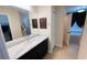 Bathroom with dark vanity, marble countertop, and large mirror at 18204 Ackerman Ave, Port Charlotte, FL 33948