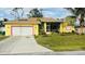 Cute yellow house with a two-car garage and a well-maintained lawn at 18204 Ackerman Ave, Port Charlotte, FL 33948