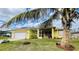 Bright yellow house with a screened porch and palm trees at 18204 Ackerman Ave, Port Charlotte, FL 33948