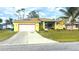 Cute yellow house with a red door and two car garage at 18204 Ackerman Ave, Port Charlotte, FL 33948