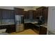 Modern kitchen with dark cabinetry, stainless steel appliances, and granite countertops at 18204 Ackerman Ave, Port Charlotte, FL 33948