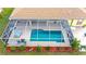 An aerial view of a refreshing blue swimming pool with a screened enclosure at 18204 Ackerman Ave, Port Charlotte, FL 33948