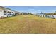 Backyard with grassy area and partial view of home and canal at 226 Spring Lake Nw Blvd, Port Charlotte, FL 33952