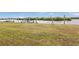 Large grassy backyard with a view of the water and dock at 226 Spring Lake Nw Blvd, Port Charlotte, FL 33952