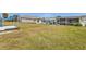 Large grassy backyard with patio, screened porch, and partial water view at 226 Spring Lake Nw Blvd, Port Charlotte, FL 33952