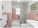 Bathroom with pink tile, white vanity, and floral shower curtain at 226 Spring Lake Nw Blvd, Port Charlotte, FL 33952