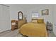Cozy bedroom with mustard bedding and wood dresser at 226 Spring Lake Nw Blvd, Port Charlotte, FL 33952