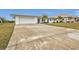 Spacious driveway leading to a white single-story home with attached garage at 226 Spring Lake Nw Blvd, Port Charlotte, FL 33952