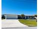 White single story home with a metal roof, attached garage, and a spacious driveway at 226 Spring Lake Nw Blvd, Port Charlotte, FL 33952