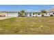 Single story home with white exterior, blue door, and grassy lawn at 226 Spring Lake Nw Blvd, Port Charlotte, FL 33952