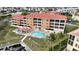 Aerial view showing condo building, pool, and surrounding landscape at 3322 Purple Martin Dr # 126, Punta Gorda, FL 33950