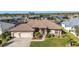 Aerial view of single-Gathering home with a large yard, three car garage, and canal access at 3411 Curacao Ct, Punta Gorda, FL 33950