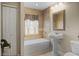 This bathroom features tiled walls, a soaking tub, and a pedestal sink with a decorative mirror at 4267 Adelaide Ave, North Port, FL 34288