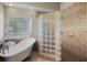 Bright bathroom features a soaking tub next to the window, and a glass block shower at 4267 Adelaide Ave, North Port, FL 34288