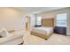 Main bedroom with tufted headboard bed and sitting area at 5274 Grove Mill Loop, Bradenton, FL 34211