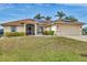 Tan house with solar panels, paver driveway, and landscaped lawn at 9214 Snapper Cir, Port Charlotte, FL 33981