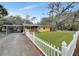 Cute yellow house with carport, white picket fence, and well-manicured lawn at 103 Atwater St, Port Charlotte, FL 33954