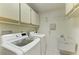 Laundry room with washer, dryer, cabinets, and utility sink at 1115 Venture Ct, Punta Gorda, FL 33983