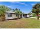 Tan house exterior with landscaped yard and palm trees at 12071 Claremont Dr, Port Charlotte, FL 33981