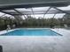 Inviting, screened-in pool with large patio and surrounding landscaping at 14303 Maysville Cir, Port Charlotte, FL 33981