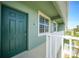 Building exterior, showing green door and white railing at 1431 Aqui Esta Dr # 221, Punta Gorda, FL 33950