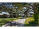 Landscaped walkway through community with mature trees and houses at 1447 Red Oak Ln, Port Charlotte, FL 33948