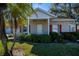 Tan house with red shutters, white trim, and lush green landscaping at 1447 Red Oak Ln, Port Charlotte, FL 33948