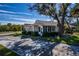 Tan house with a screened porch and two-car garage, surrounded by lush landscaping at 1447 Red Oak Ln, Port Charlotte, FL 33948