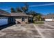 Two-car garage with AC unit and surrounding landscaping at 1447 Red Oak Ln, Port Charlotte, FL 33948