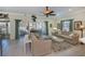 Bright living room with tiled floors, beige sofas, and access to a screened porch at 1447 Red Oak Ln, Port Charlotte, FL 33948