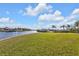 Expansive grassy yard leading to a serene canal at 18138 Eau Gallie Cir, Port Charlotte, FL 33948