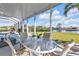 Enjoy waterfront dining on this peaceful patio with glass-top table at 18138 Eau Gallie Cir, Port Charlotte, FL 33948