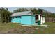 Teal-colored house with covered carport and grassy yard at 2115 Myrtle Ave, Punta Gorda, FL 33950