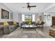 Bright living room features neutral colored sofas, a coffee table, and wood-look tile floors at 22259 Priscilla Ave, Port Charlotte, FL 33954