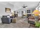 Spacious living room with gray sofas, tile floor, and ceiling fan at 22259 Priscilla Ave, Port Charlotte, FL 33954