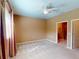 Spacious bedroom with ceiling fan, window, and access to bathroom at 24067 Park Place S Dr # 71, Port Charlotte, FL 33980