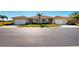 Three-unit building exterior with two-car garages and palm trees at 24067 Park Place S Dr # 71, Punta Gorda, FL 33980